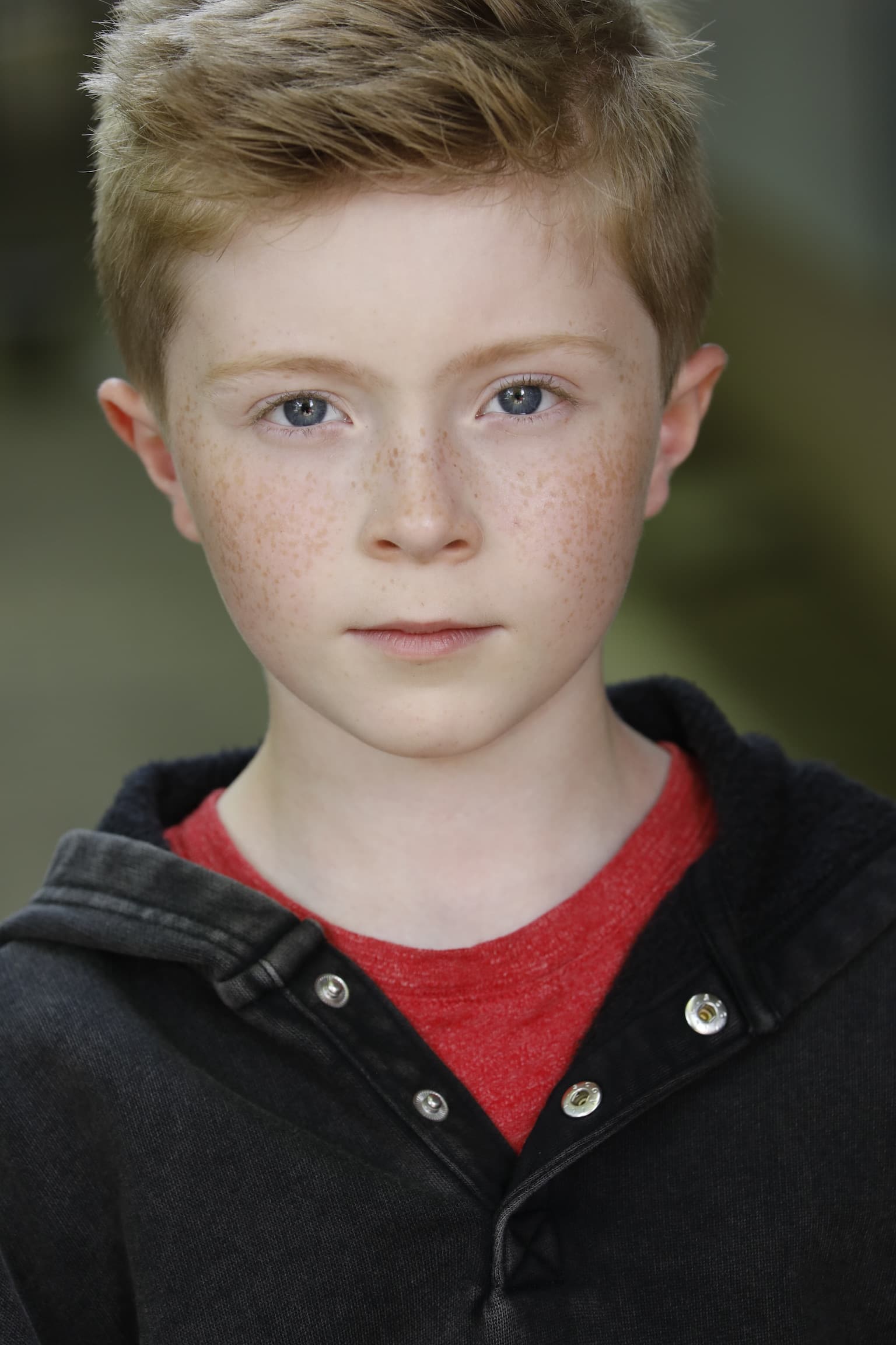 Kaden Stoneking in a dark jacket over a red shirt, 2025 headshot